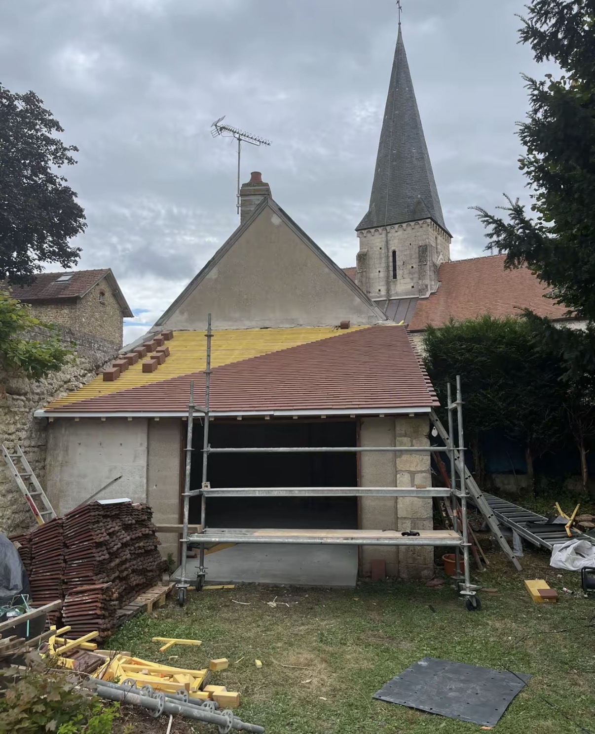Réfection de toiture en tuile plate près d'une église de village